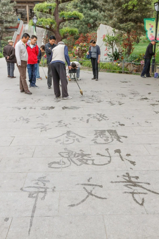 Мастер в парке Таожаньтин (Пекин) пишет иероглифы в зеркальном отображении